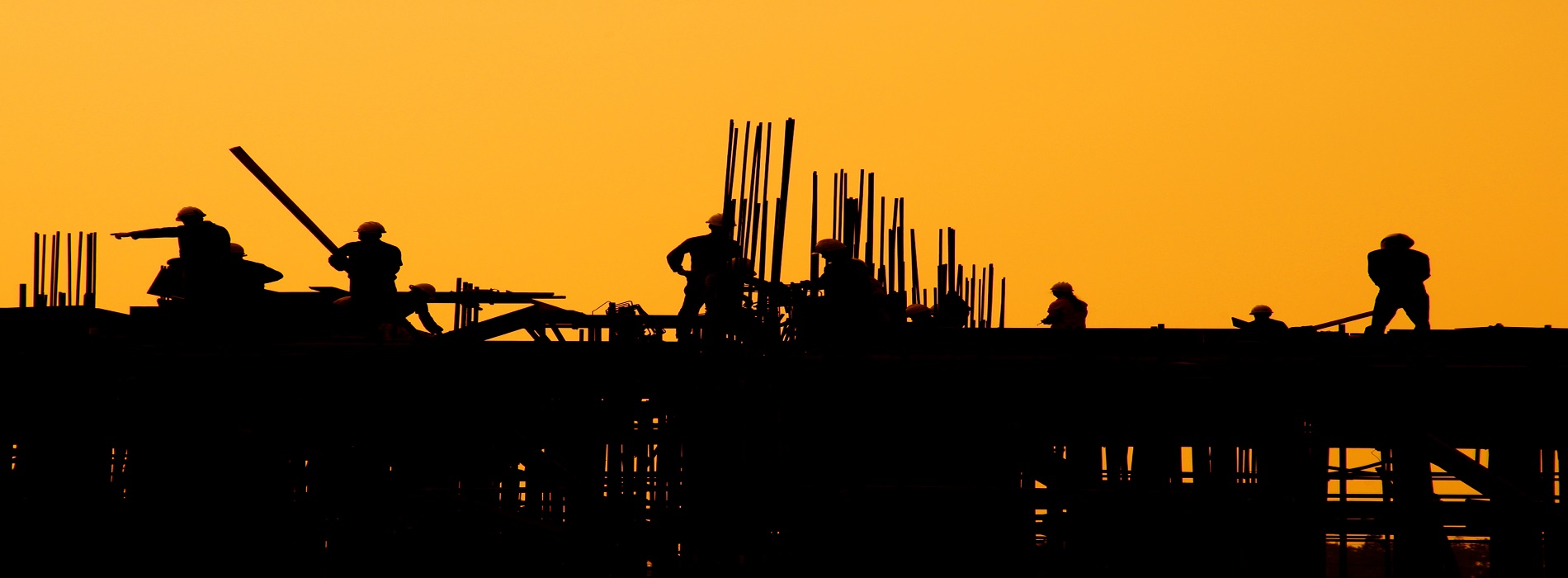 Construction workers at sunset.